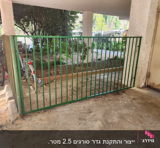גדר מתכת ירוקה עם אופניים ברקע